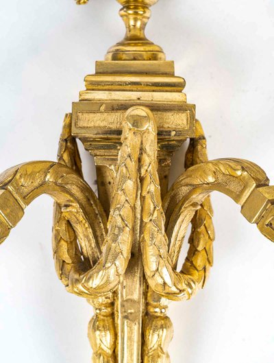 Coppia di appliques in bronzo cesellato e dorato in stile Luigi XVI con due bracci di luce 1820 ca.