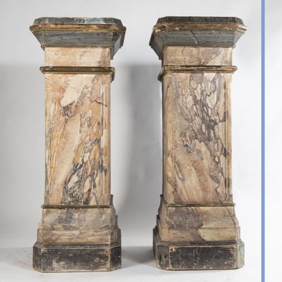 Paire de sculptures en terre cuite sur deux colonnes en bois peint en trompe-l'oeil, XIXe