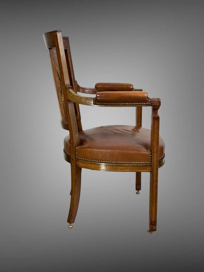 Empire-style armchair in walnut decorated with gilt bronze and covered in brown leather