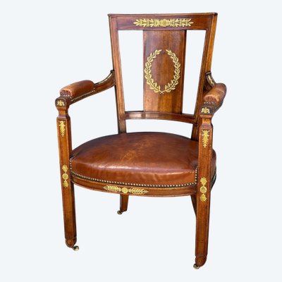 Empire-style armchair in walnut decorated with gilt bronze and covered in brown leather