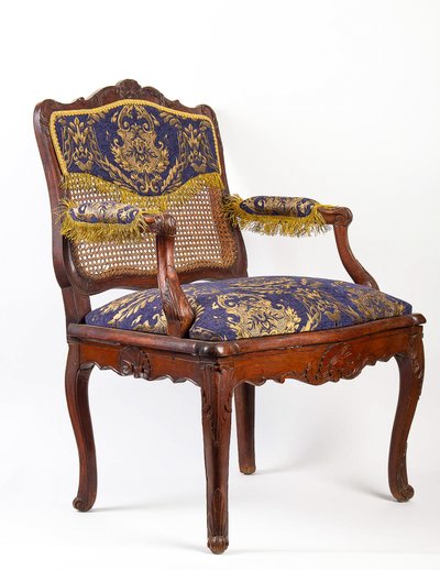 Fauteuil à fond de cannes en bois naturel mouluré et sculpté d’époque Régence vers 1720