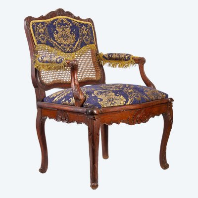 Fauteuil à fond de cannes en bois naturel mouluré et sculpté d’époque Régence vers 1720