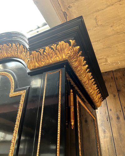 Large wardrobe in blackened and gilded wood