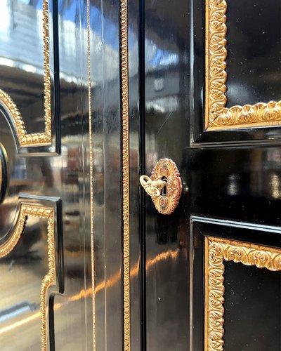 Large wardrobe in blackened and gilded wood