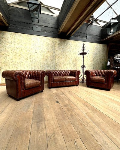 Salon chesterfield avec un canapé et deux fauteuils