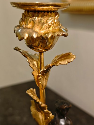Pair of Candlesticks with Antique Figures and Poppies in patinated and gilded bronze, Directoire period.