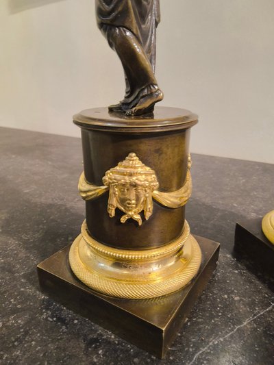 Pair of Candlesticks with Antique Figures and Poppies in patinated and gilded bronze, Directoire period.