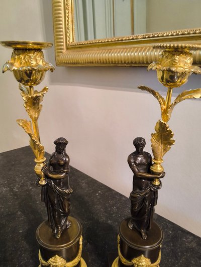 Pair of Candlesticks with Antique Figures and Poppies in patinated and gilded bronze, Directoire period.