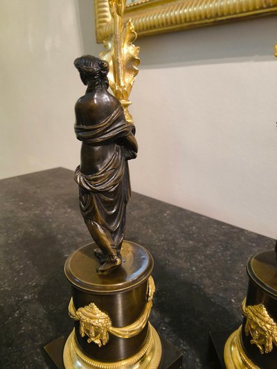 Pair of Candlesticks with Antique Figures and Poppies in patinated and gilded bronze, Directoire period.