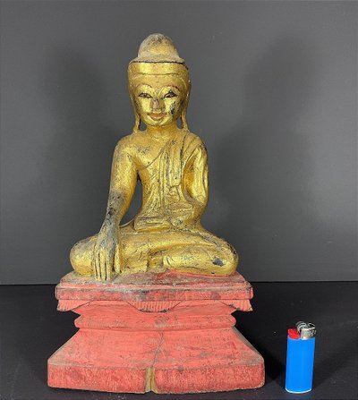 Birma, Mitte des 20. Jahrhunderts, rot und gold lackierte Holzskulptur, die einen sitzenden Buddha darstellt.