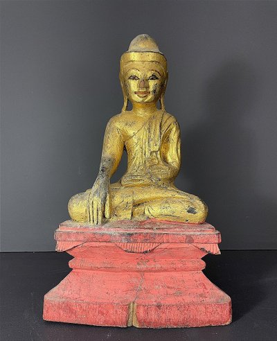 Birma, Mitte des 20. Jahrhunderts, rot und gold lackierte Holzskulptur, die einen sitzenden Buddha darstellt.