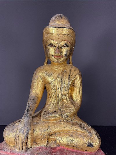 Birma, Mitte des 20. Jahrhunderts, rot und gold lackierte Holzskulptur, die einen sitzenden Buddha darstellt.
