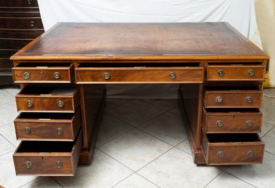 Antica scrivania inglese in mogano con nove cassetti. Inghilterra, XIX secolo.