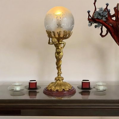 LAMPADA DEL XIX SECOLO IN BRONZO DORATO CHE RAPPRESENTA UN TRITONE CON BASE IN MARMO A DOPPIA CODA