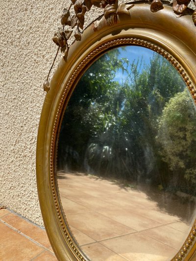 Miroir ovale à fronton fleuri en bois doré sculpté, époque Napoléon III – XIXᵉ siècle - 65x96 cm