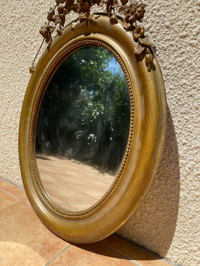 Miroir ovale à fronton fleuri en bois doré sculpté, époque Napoléon III – XIXᵉ siècle - 65x96 cm