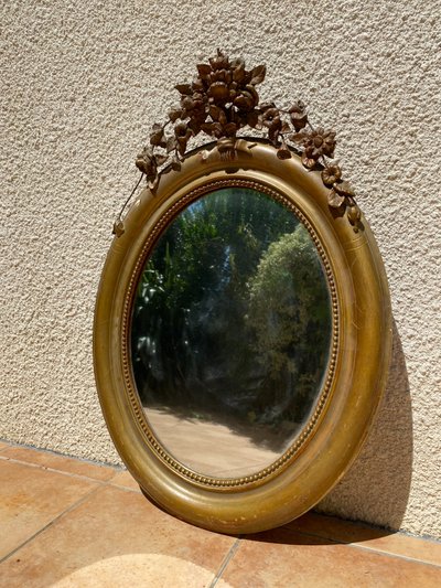 Miroir ovale à fronton fleuri en bois doré sculpté, époque Napoléon III – XIXᵉ siècle - 65x96 cm