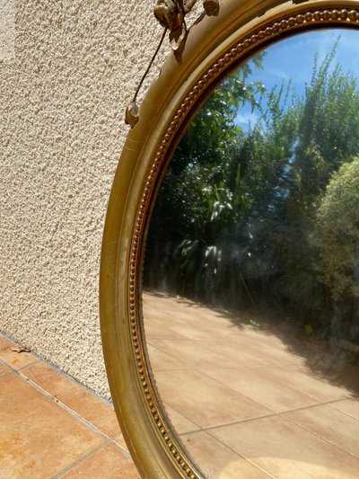 Miroir ovale à fronton fleuri en bois doré sculpté, époque Napoléon III – XIXᵉ siècle - 65x96 cm