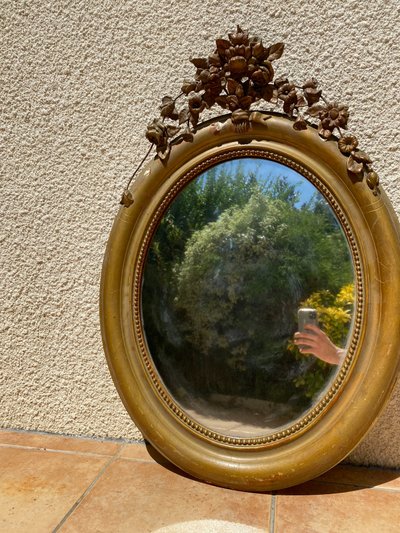 Miroir ovale à fronton fleuri en bois doré sculpté, époque Napoléon III – XIXᵉ siècle - 65x96 cm