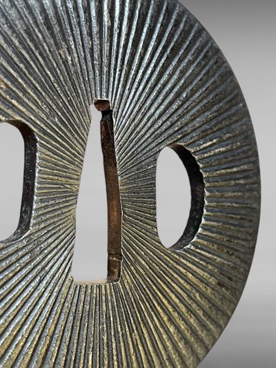 Tsuba Maru Gata in ferro battuto con motivo radiante - Periodo Edo (1603-1868).
