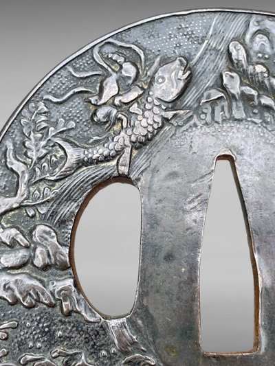 Tsuba Maru Gata in ferro battuto con due pescatori su sfondo Nanako - Periodo Edo (1603-1868)
