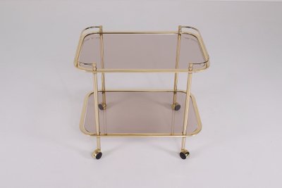 Rollendes Beistelltischchen aus Messing und Rauchglas 1970.