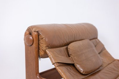 Poltrona e pouf in olmo biondo e pelle. Circa 1970. LS61501217