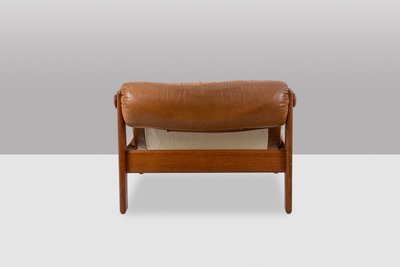 Poltrona e pouf in olmo biondo e pelle. Circa 1970. LS61501217