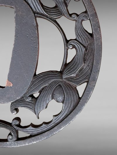 Tsuba maru gata in openwork iron with plant motifs, signed and located - Edo period - D. 7 cm.