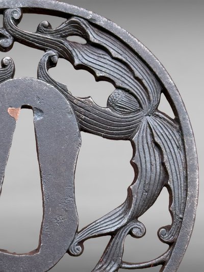 Tsuba maru gata in openwork iron with plant motifs, signed and located - Edo period - D. 7 cm.
