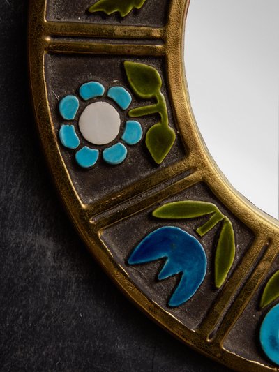 Round ceramic mirror by Mithe Espelt with blue flower decorations