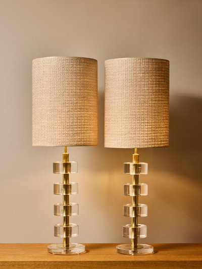Pair of stacked solid glass disc table lamps with polished brass columns