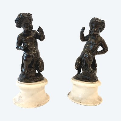 Paar bronzene Putten mit brauner Patina auf weißem Marmorsockel