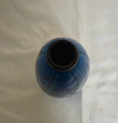 Eine sehr hübsche Vase aus intensiv blau glasierter Keramik, verziert mit dezenten Wellenmustern im Material.
