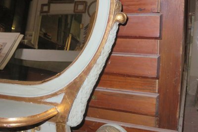 Specchio ovale, italiano, in legno dipinto e dorato, XIX secolo.