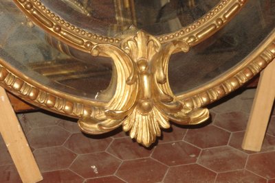 Grande specchio ovale con frontone, in legno dorato, XIX secolo.
