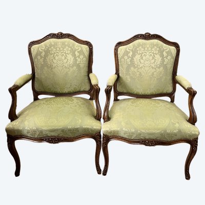 Paire de larges fauteuils en noyer sculpté . 