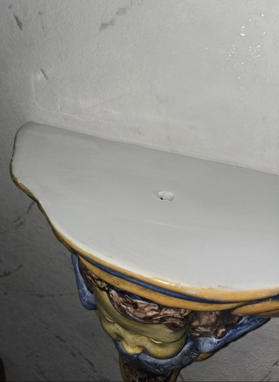 Consolle a muro in ceramica smaltata con decorazione putto