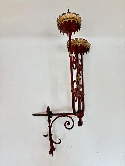 PAIR OF WROUGHT IRON CANDLE-SOCKET WALL LIGHTS, STAINED RED AND GOLD.