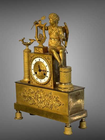 PENDULE ÉPOQUE EMPIRE EN BRONZE DORÉ A DECOR D'EROS JOUANT DE LA HARPE