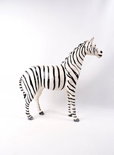 Scultura in cuoio dipinto raffigurante una zebra con occhi di vetro nero, Kenya, metà del XX secolo.