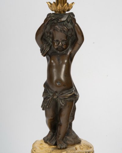 Pair of candelabra featuring putto figures, in patinated bronze and gilded bronze