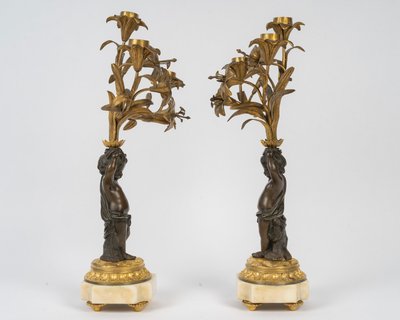 Pair of candelabra featuring putto figures, in patinated bronze and gilded bronze
