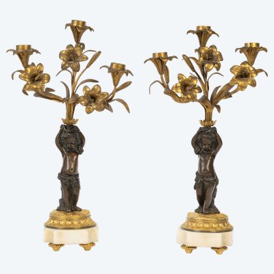 Pair of candelabra featuring putto figures, in patinated bronze and gilded bronze