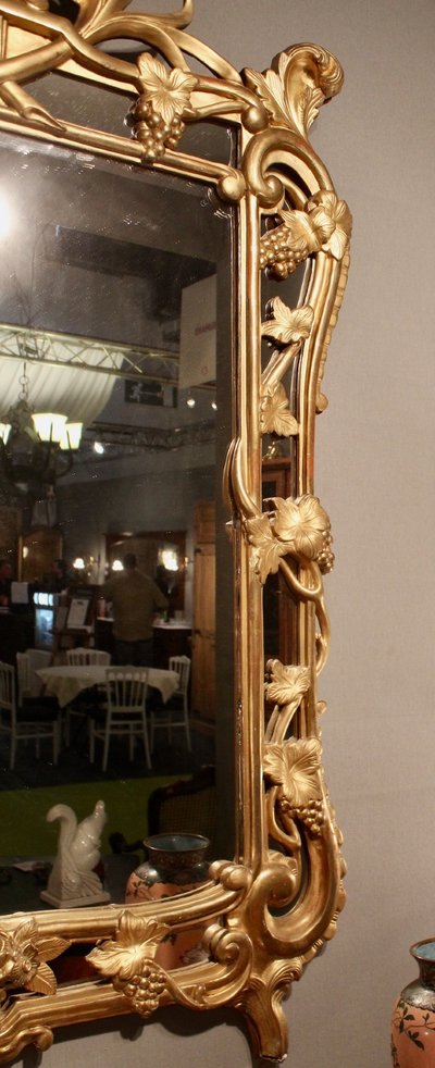 Important mirror with sculpted reserves of grapes