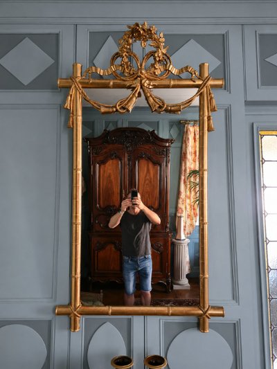 Miroir d'époque Napoléon III à l'imitation du bambou et à décor de draperies à houppes.