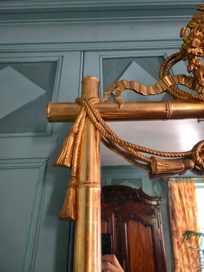 Miroir d'époque Napoléon III à l'imitation du bambou et à décor de draperies à houppes.