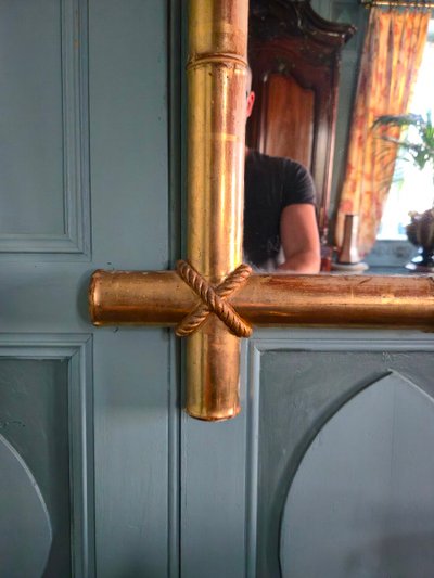 Miroir d'époque Napoléon III à l'imitation du bambou et à décor de draperies à houppes.