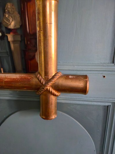 Miroir d'époque Napoléon III à l'imitation du bambou et à décor de draperies à houppes.