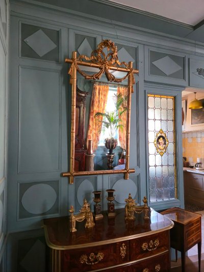 Miroir d'époque Napoléon III à l'imitation du bambou et à décor de draperies à houppes.